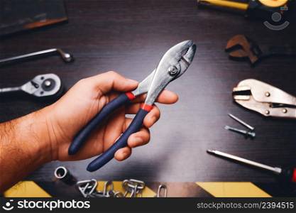 Metal pliers isolated on the mechanic hand with a mechanic tools background