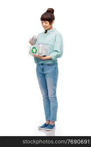 metal recycling, waste sorting and sustainability concept - smiling young asian woman holding plastic box with tin cans over white background. smiling young asian woman sorting metallic waste