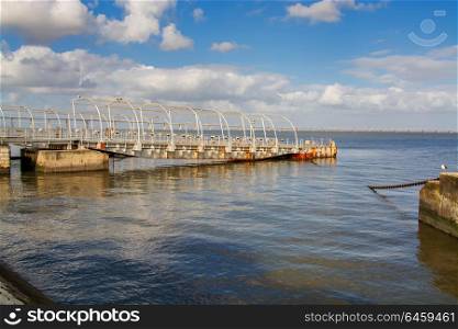 metal rusted structure pier in the water wit blue hazy sky