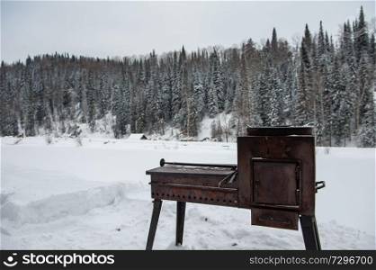 Metal rusty grill in winter forest, relax and resting on the nature concept. Metal rusty grill in winter forest