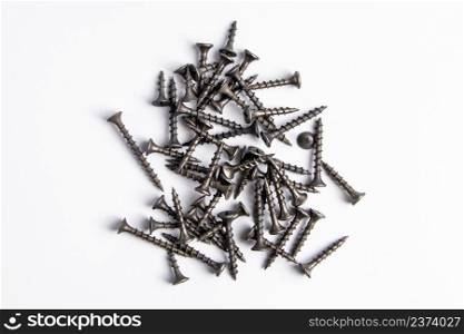 Metal screws on a white background. Set of building tools for repair. Metal screws on a white background. Set of building tools for repair.