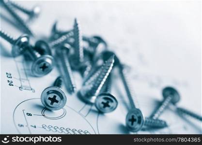 metal screws over technical drawing background