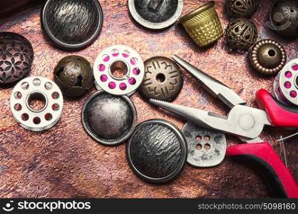 metal sewing button. metal sewing button and thread coil on copper retro background