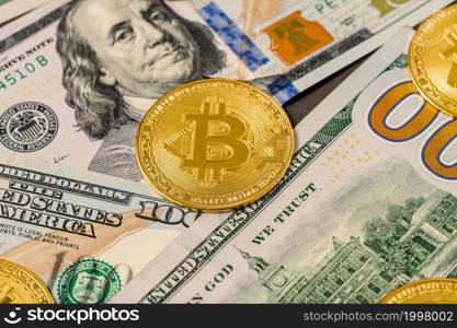 Metal shiny bitcoin crypto currency coins on US dollar bills.