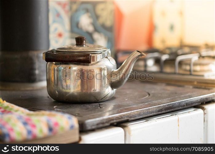Metal tea cooker on a rustic old oven