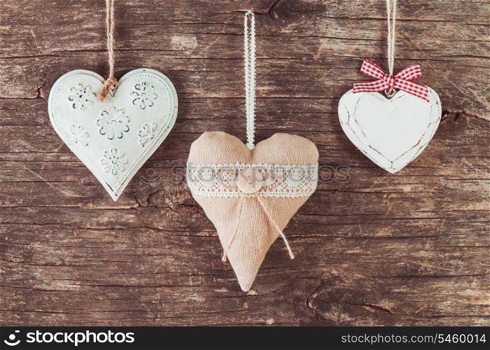 Metal, textile and wooden heart on the old natural background