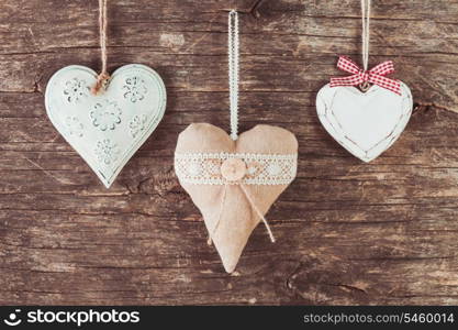 Metal, textile and wooden heart on the old natural background