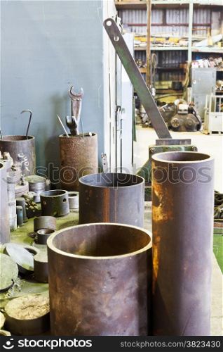 metal tools and workpiece on workbench in turning shop