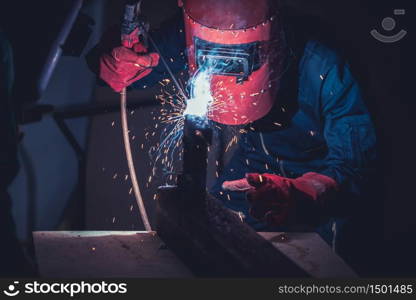 Metal welding steel works using electric arc welding machine to weld steel at factory. Metalwork manufacturing and construction maintenance service by manual skill labor concept.