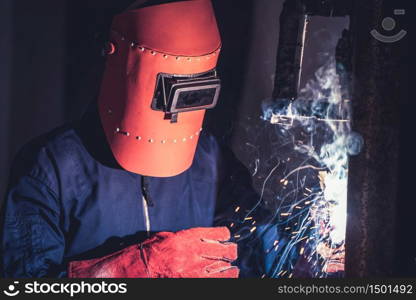 Metal welding steel works using electric arc welding machine to weld steel at factory. Metalwork manufacturing and construction maintenance service by manual skill labor concept.