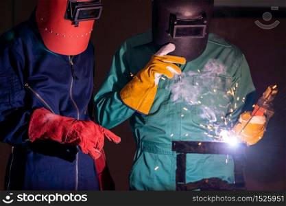 Metal welding steel works using electric arc welding machine to weld steel at factory. Metalwork manufacturing and construction maintenance service by manual skill labor concept.