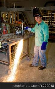 Metal worker using a track burner to cut steel with heat.