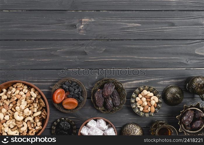 metallic bowl with sweet lukum dried fruits nuts black wooden desk ramadan