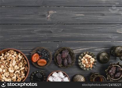 metallic bowl with sweet lukum dried fruits nuts black wooden desk ramadan