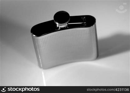 metallic flask on gray background with shadows