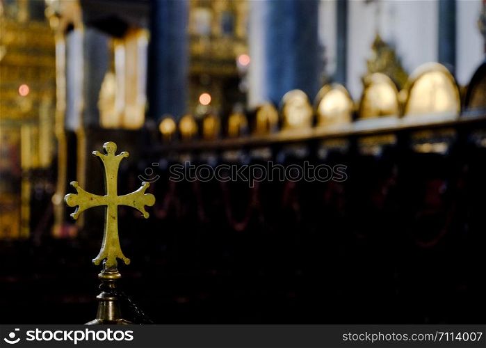 Metallic rounded cross inside a church