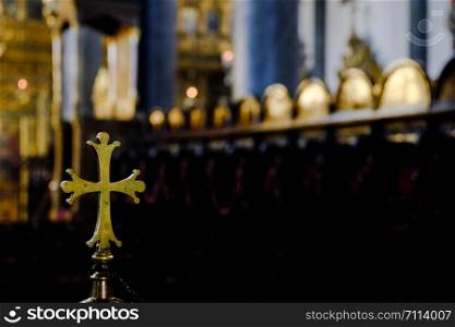 Metallic rounded cross inside a church