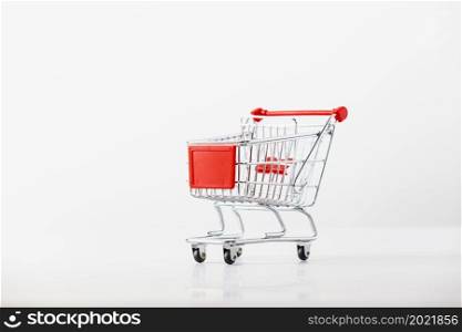 Metallic shopping cart trolley on light gray background with copy space. Shopping symbol.