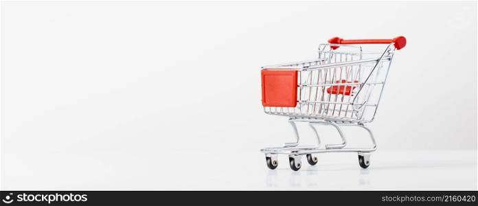 Metallic shopping cart trolley on light gray background with copy space. Shopping symbol. Banner