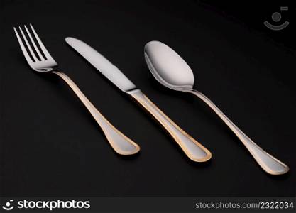 metallic silver cutlery on black background