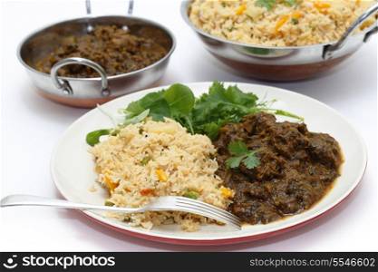 Methi gosht or fenugreek lamb, served with tomato (thakkali) biryani and a leafy salad, with kadasi of the rice and meat behind