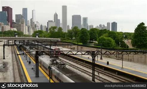 Metra train network in Chicago Downtown. Commuters traveling by train to their offices in the financial district of Illinois in the United States of America. Trains arriving at Chicago skyline early in the morning.