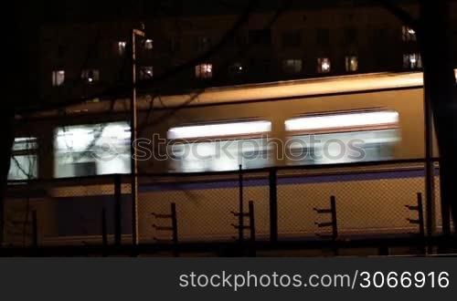 Metro subway train outdoors at night.