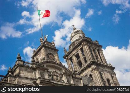 Metropolitan cathedral of Mexico city in Zocalo square and mexican flag.