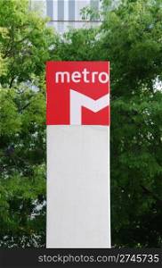 metropolitan sign with green trees in the background