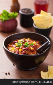 mexican chili con carne in black plate with ingredients