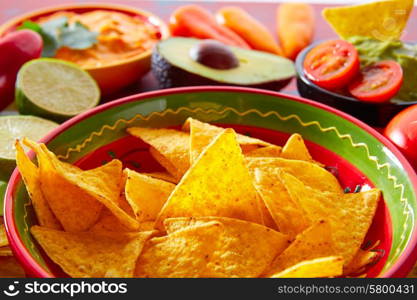 Mexican food nachos and guacamole with chili peppers and sauces