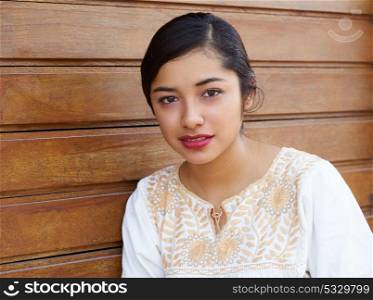Mexican latin woman with ethnic dress in wooden background