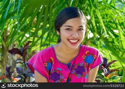 Mexican latin woman with mayan dress smiling in the jungle