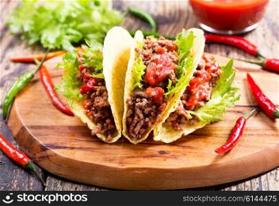 mexican tacos with meat and salsa on a wooden table