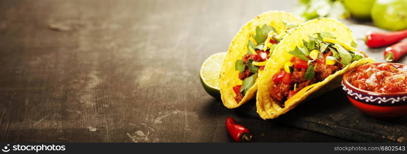 Mexican tacos with meat, beans and salsa on rustic background