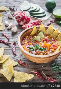 Mexican tortilla soup on the wooden background