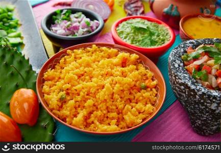 Mexican yellow rice with chilis and sauces in colorful background