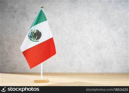 Mexico table flag on white textured wall. Copy space for text, designs or drawings