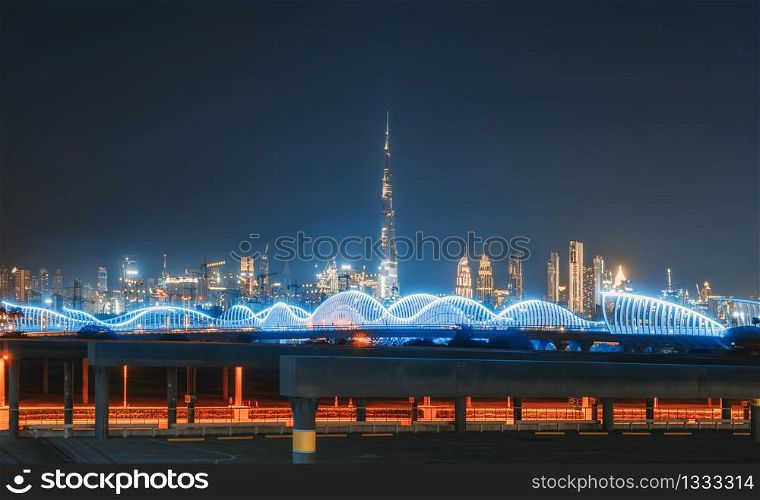 Meydan Bridge and street road or path way on highway with modern architecture buildings in Dubai Downtown skyline at night, urban city at night, United Arab Emirates or UAE.
