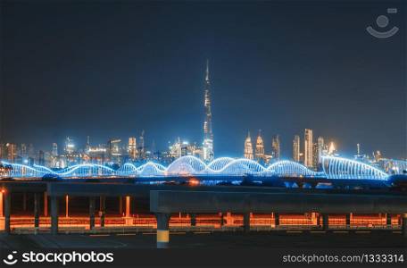 Meydan Bridge and street road or path way on highway with modern architecture buildings in Dubai Downtown skyline at night, urban city at night, United Arab Emirates or UAE.