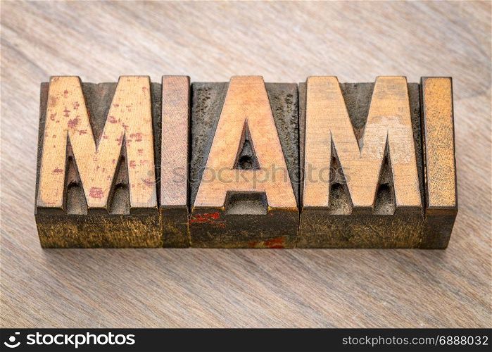 Miami word abstract in vintage letterpress wood type against grained wooden background