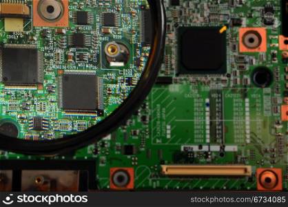 Microchips On Circuit Board Seen By Magnifying Glass