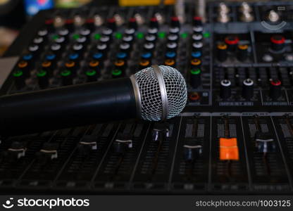 Microphone and audio sound mixer analog at the sound control room on blurred background