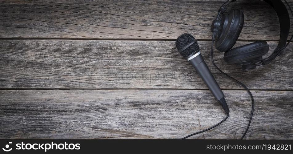 Microphone and headphone on a wooden background