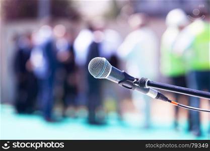 Microphone in focus against blurred audience