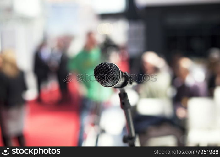 Microphone in focus against blurred audience