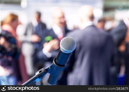 Microphone in focus against blurred people