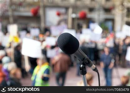 Microphone in focus against blurred protesters