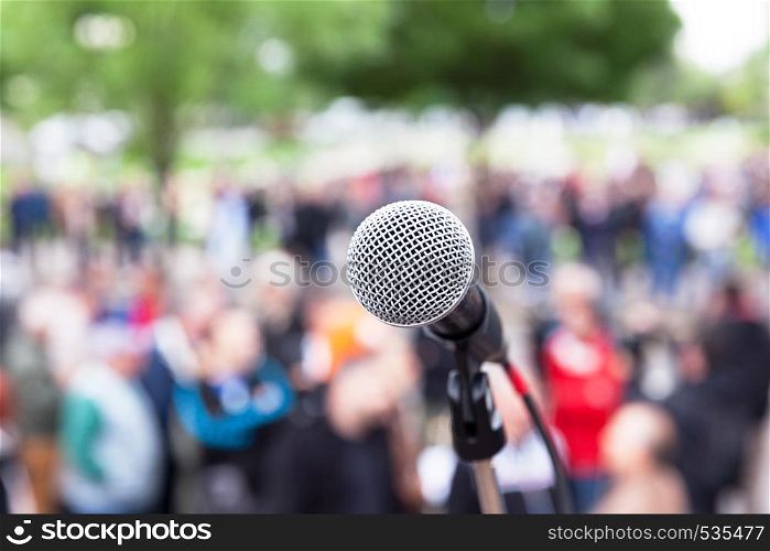 Microphone in focus, blurred crowd in the background