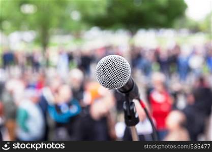 Microphone in focus, blurred crowd in the background